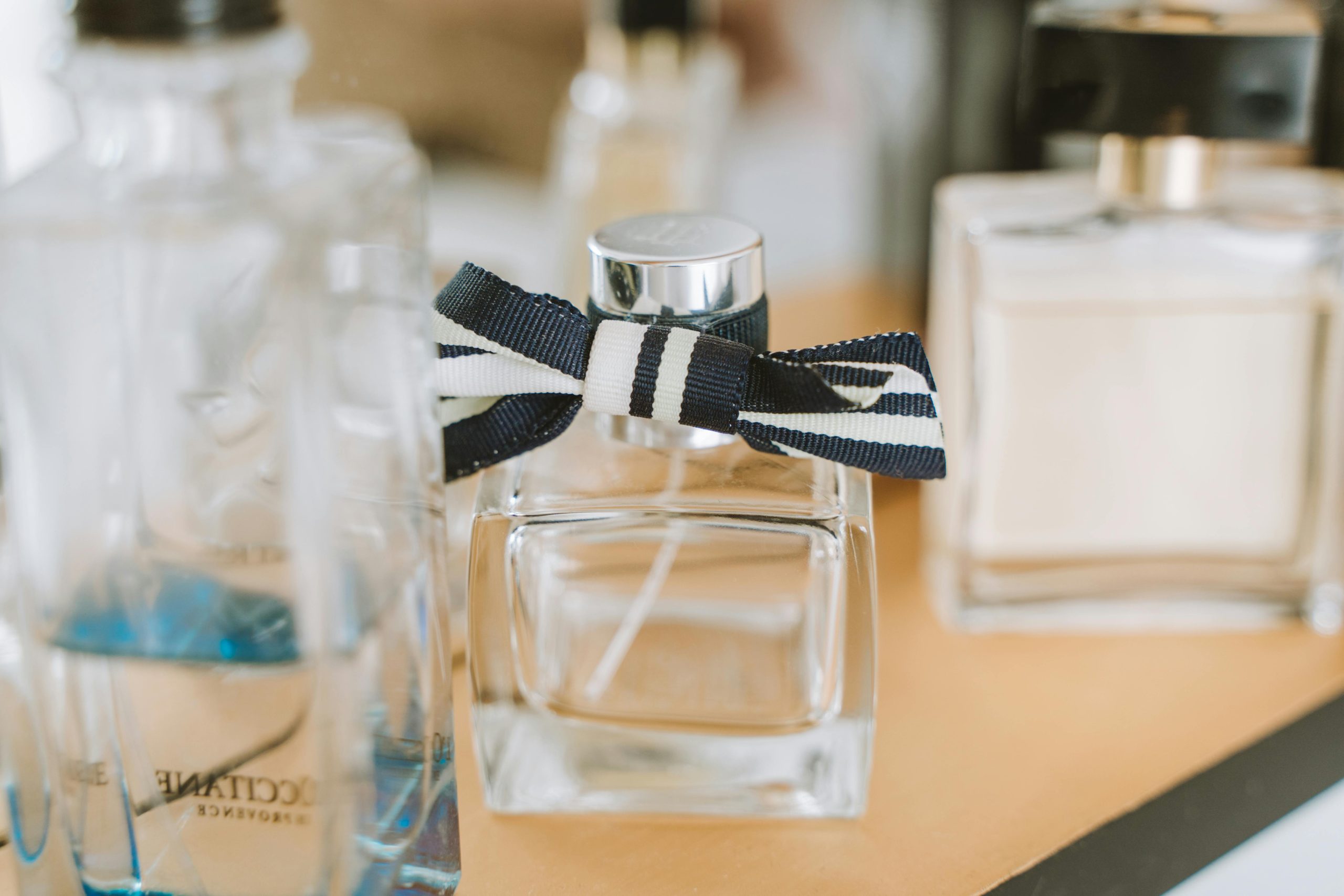 Clear Glass Perfume Bottle on Brown Table